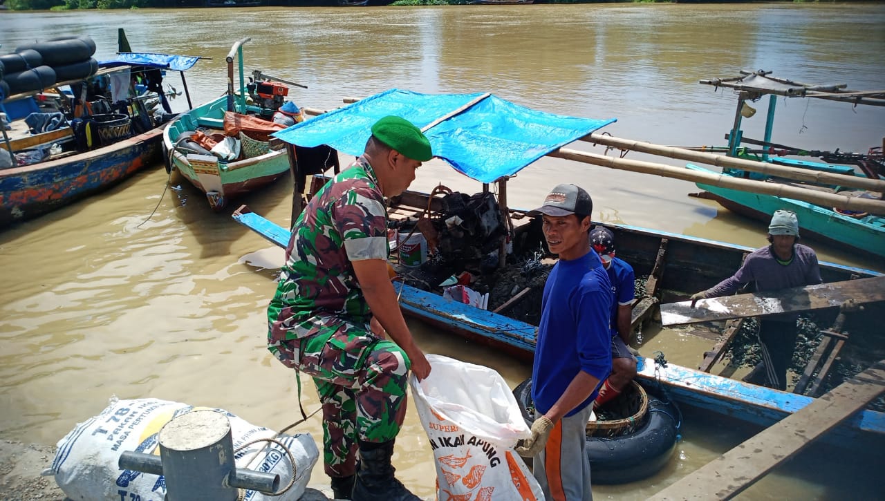 Kegiatan Komsos Babinsa Sidayu, Bantu menurunkan Kerang Hijau dari Perahu Nelayan Binaan.